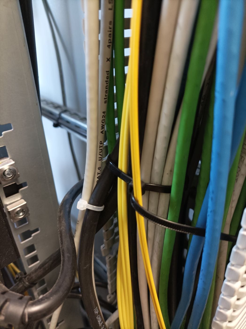 Instalación de equipos y peinado de cableado en rack de empresa: Mazo de cables agrupado con bridas